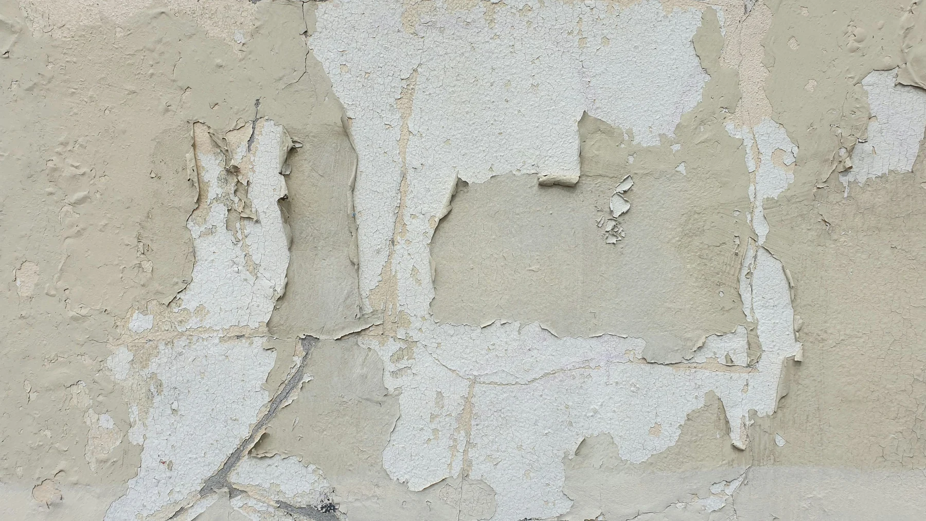Cracked and peeling paint on a wall in disrepair